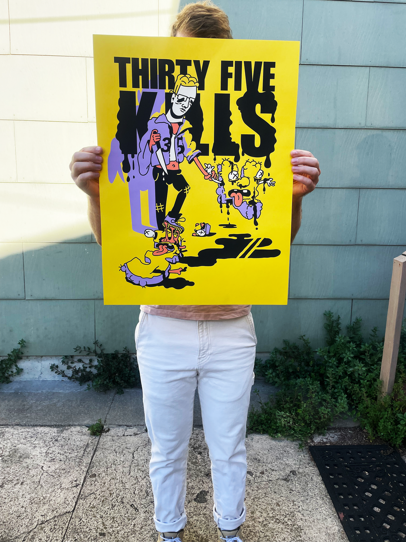 A person holding the bright yellow Thirty-Five Kills screen print